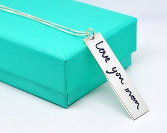 May include: A silver necklace with a rectangular pendant that says "Love you mom" in cursive handwriting.