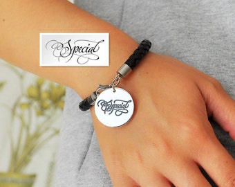May include: A black leather bracelet with a silver charm that says "Special" in cursive.