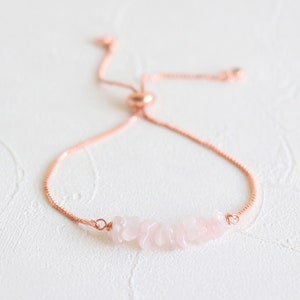 May include: A rose quartz gemstone bracelet with a rose gold chain and adjustable sliding knot closure.