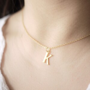 May include: A gold chain necklace with a gold letter K pendant.