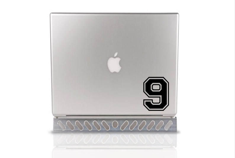 May include: A silver laptop computer with a black number 9 sticker on the back. The number is in a varsity style font.