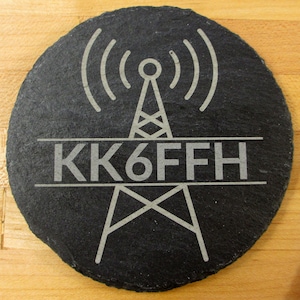 May include: Black slate coaster with a white radio tower and the call sign "KK6FFH" engraved on it.