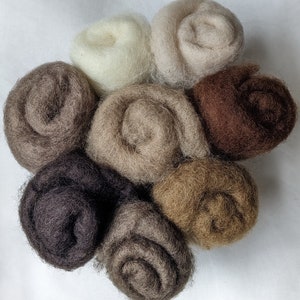 Peut inclure: Collection de neuf mèches de laine de différentes nuances de marron, beige et crème. La laine est enroulée serrée, mettant en valeur les variations de texture et de couleur naturelles. Idéal pour l'art et l'artisanat de la fibre.