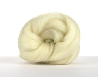 May include: A ball of off-white wool roving, a type of fiber used for spinning yarn or felting.