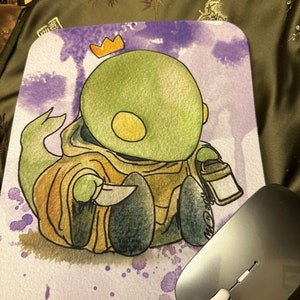 May include: A watercolor illustration of a green creature wearing a brown robe and a gold crown. The creature is holding a knife and a lantern. The background is a purple watercolor wash.