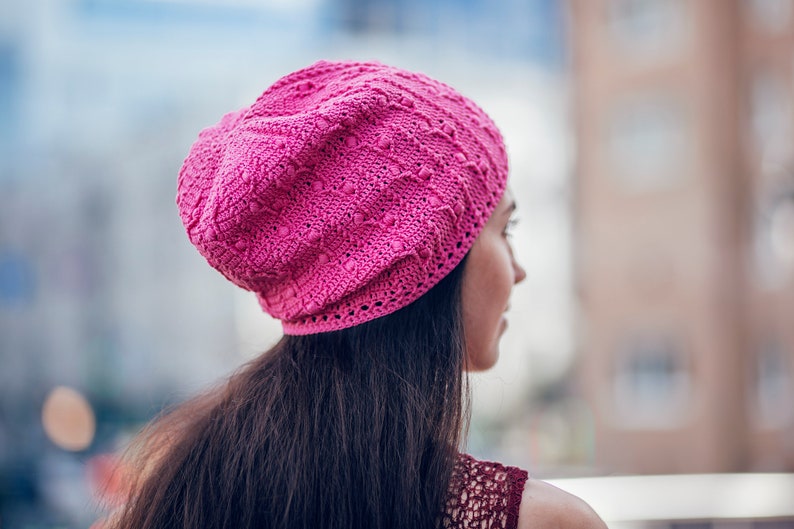 Pink  slouchy  crochet  beanie on a woman's head with dark hair