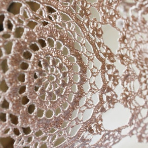 Detailed macro photo of the large circular crochet motif, highlighting the fine linen yarn texture and airy openwork design.