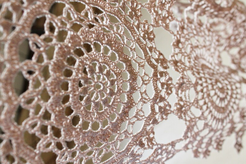Detailed macro photo of the large circular crochet motif, highlighting the fine linen yarn texture and airy openwork design.
