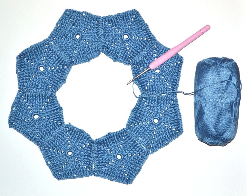 The process of joining crocheted pentagon motifs into the top part of a woman's hat.