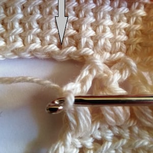The process of crocheting Tunisian stitch using fingering weight light-colored yarn.