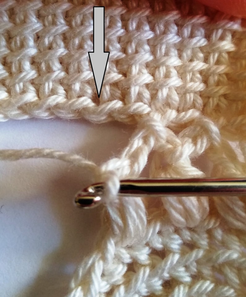 The process of crocheting Tunisian stitch using fingering weight light-colored yarn.