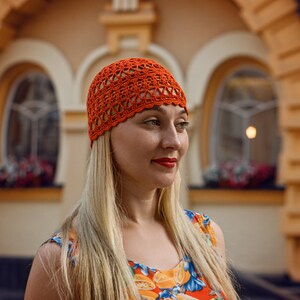 The woman in bright attire is wearing a lightweight crocheted cotton hat with an easy to crochet pattern.