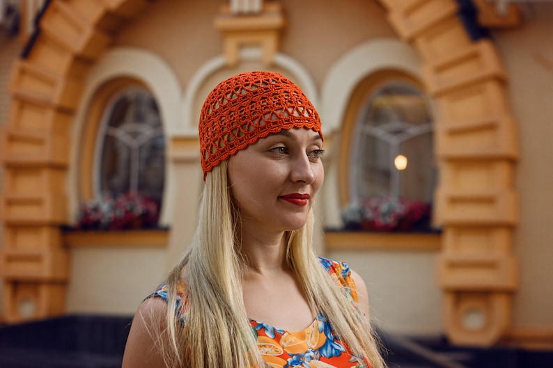 The woman in bright attire is wearing a lightweight crocheted cotton hat with an easy to crochet pattern.