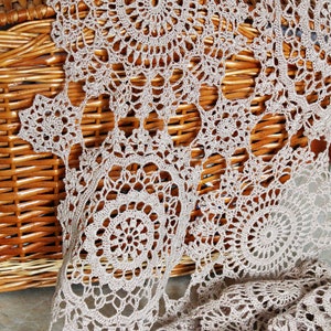 Lightweight, elegant crochet scarf by Kate Kosenko Veselunka, hanging on a hanger with natural folds and flowing design.