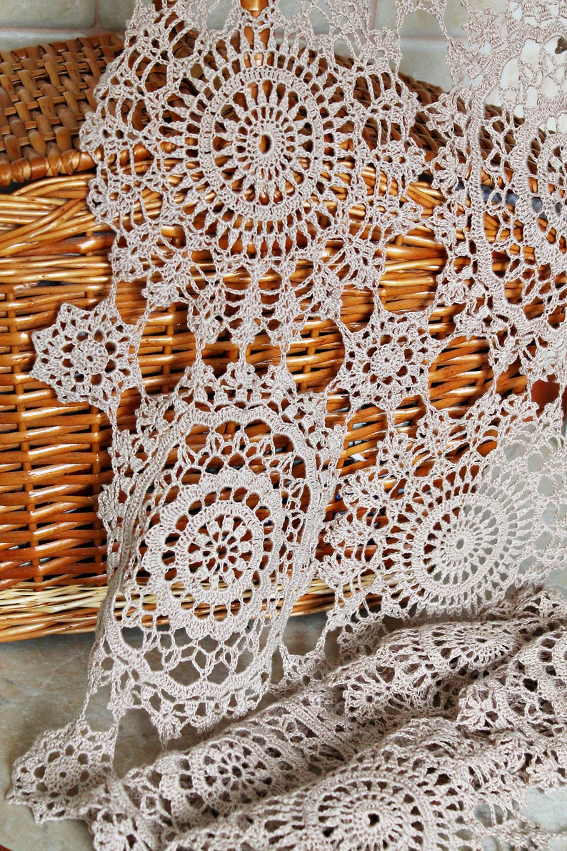 Lightweight, elegant crochet scarf by Kate Kosenko Veselunka, hanging on a hanger with natural folds and flowing design.