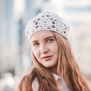 Crochet beret with floral pattern showcasing on a woman head