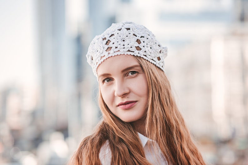 Crochet beret with floral pattern showcasing on a woman head
