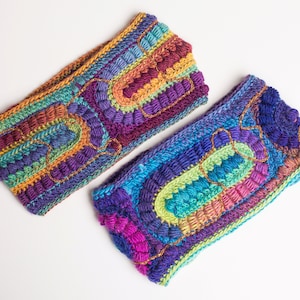 May include: Two colorful crocheted headbands with a multi-colored striped pattern and raised textured details. The headbands are made with a variety of colors, including purple, blue, green, orange, and yellow.