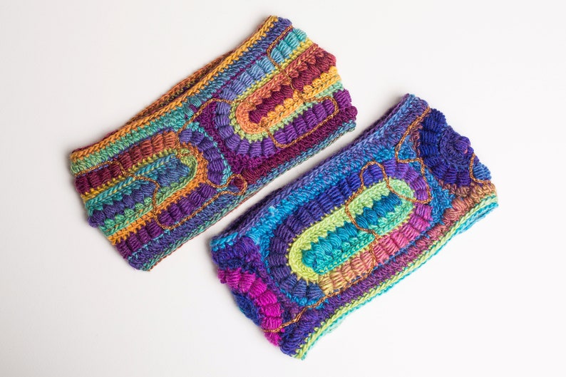 May include: Two colorful crocheted headbands with a multi-colored striped pattern and raised textured details. The headbands are made with a variety of colors, including purple, blue, green, orange, and yellow.