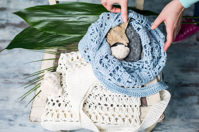 Summery handmade crochet bag in light blue, minimal lace pattern, styled for beach vibes with marine props