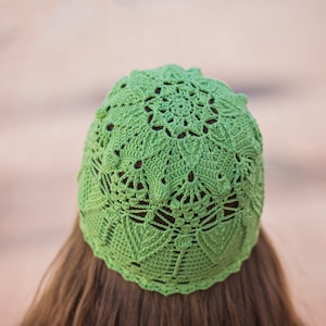 May include: A green crocheted hat with a lacy design.