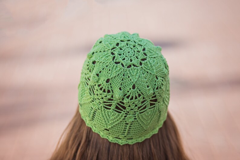 May include: A green crocheted hat with a lacy design.