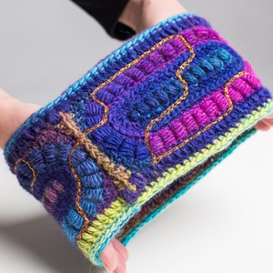 May include: A colorful crocheted headband with a textured design and gold thread accents.