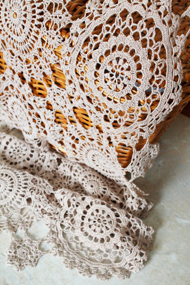 Summer crochet scarf in beige linen yarn hanging naturally on a hanger, showing beautiful draping and airy texture.
