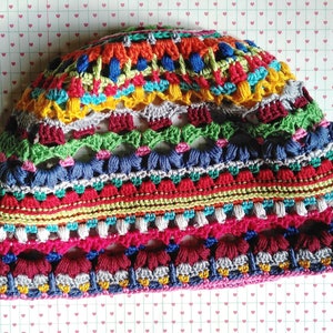 Close-up photo of a handmade multicolored striped funky crocheted hat.