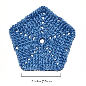 A pentagon crocheted element made from fine yarn. Blue on a white background with a textured patternof front post double crochet stitches.