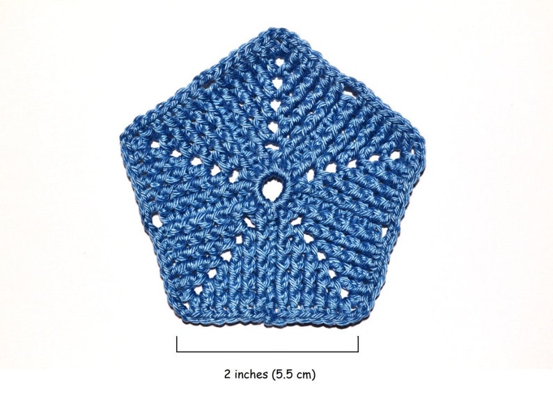 A pentagon crocheted element made from fine yarn. Blue on a white background with a textured patternof front post double crochet stitches.
