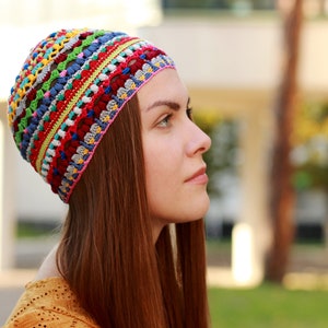 The woman showcases on her head a handmade crocheted hat with a unique pattern by an independent designer.