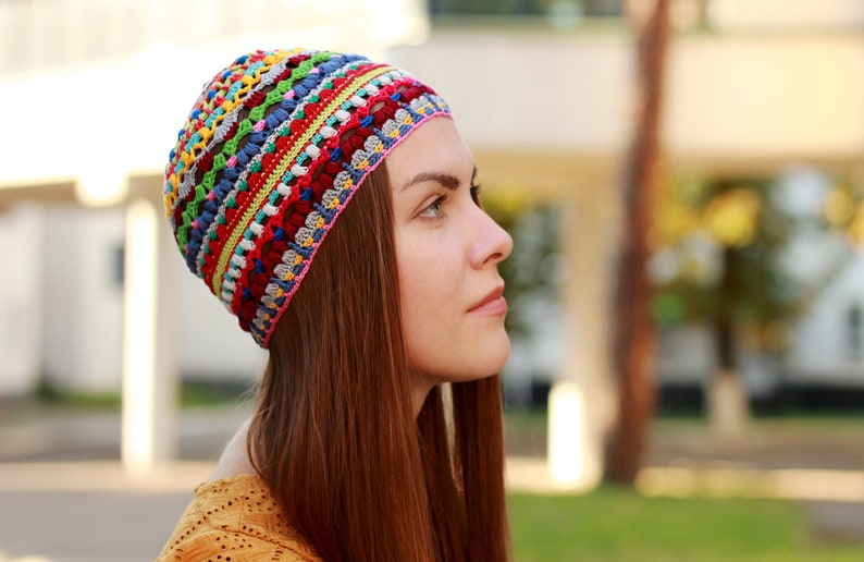 The woman showcases on her head a handmade crocheted hat with a unique pattern by an independent designer.