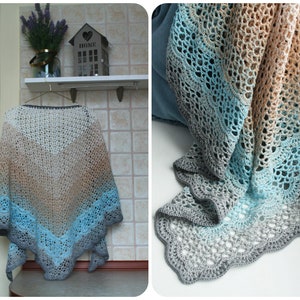 Può includere: Uno scialle all'uncinetto con un gradiente di colori blu, grigio e beige. Lo scialle ha un bordo a festoni e un delicato motivo a pizzo.