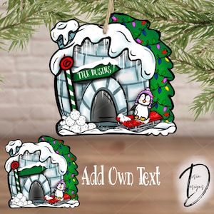 May include: A Christmas ornament featuring a cartoon igloo with a penguin riding a sled. The igloo has a sign that reads "The Dusins".
