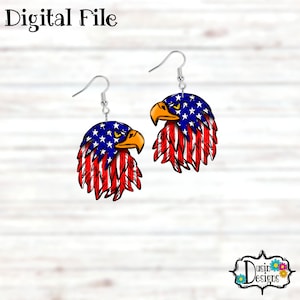 May include: A pair of dangle earrings featuring a red, white and blue bald eagle head with a feathered design. The eagle is depicted with a fierce expression and has the American flag pattern on its feathers.