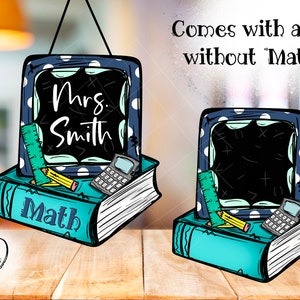 Puede incluir: Una pizarra azul y blanca con lunares con el texto "Mrs. Smith" colgada sobre una pila de libros con una regla, un lápiz y una calculadora. El texto "Math" está en la parte delantera de la pila de libros.