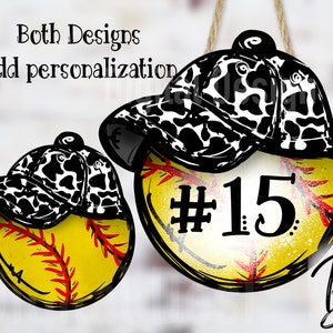 May include: Two yellow and red softball ornaments with black and white cow print baseball caps on top. One ornament has the number 15 on it.