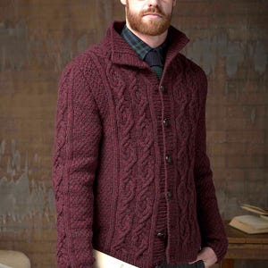 May include: A burgundy cable knit cardigan with a button-up front and a collar. The cardigan is made from a soft, warm wool blend and has a classic, timeless style.