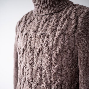 May include: A brown turtleneck sweater with a cable knit pattern.