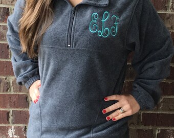May include: A charcoal gray fleece pullover with a teal monogram "ELF" embroidered on the chest. The pullover has a quarter-zip closure and a kangaroo pocket.