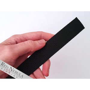 May include: Black woven cotton webbing strap. The strap is approximately 1 inch wide.