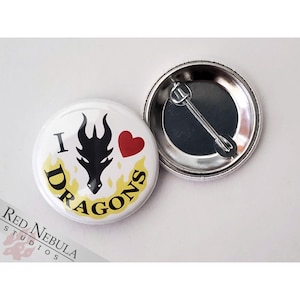 May include: A white button with a black dragon, red heart, and yellow flames. The text "I love Dragons" is written around the dragon. The back of the button is silver.