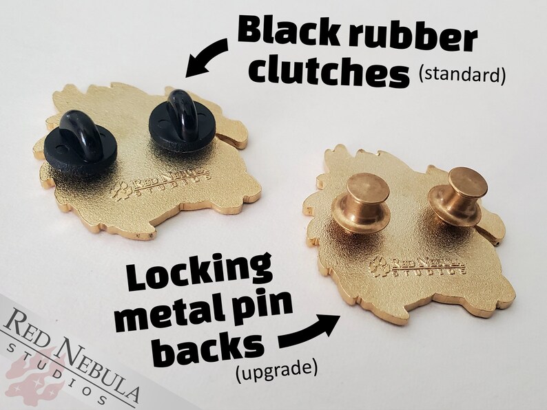 May include: Two gold-colored metal pins with different backings: black rubber clutches and locking metal pin backs. The pins have a detailed design and the text "Red Nebula Studios".