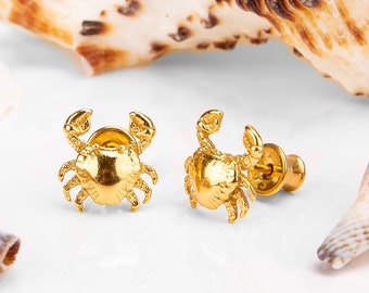 May include: A pair of gold-toned crab stud earrings. The earrings are small and delicate, and they feature a realistic crab design.