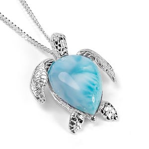 Op de afbeelding: Zilveren schildpad hanger ketting met een blauwe en witte edelsteen. De schildpad is gedetailleerd met een getextureerde schelp en heeft een gladde, gepolijste edelsteen.