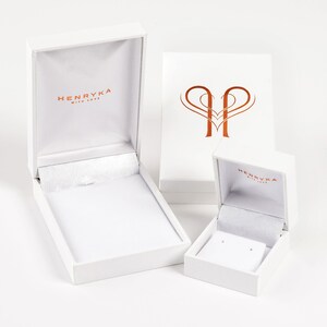 May include: Two white gift boxes with the logo "Henryka with love" printed on the top. The larger box is open and the smaller box is closed.