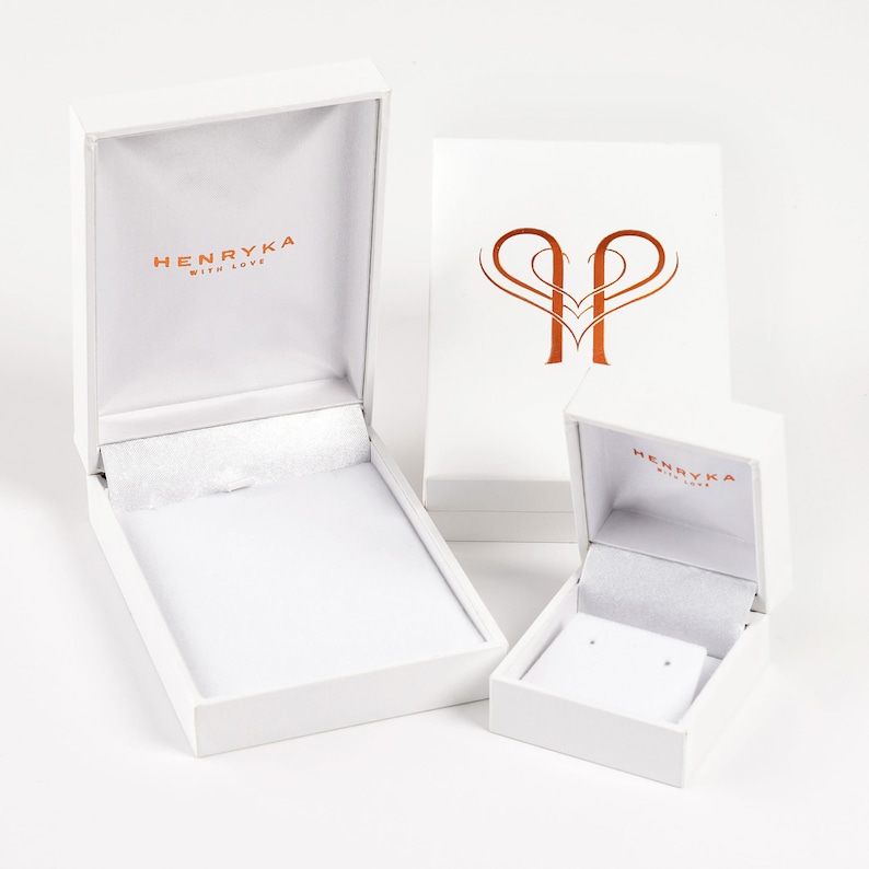 May include: Two white gift boxes with the logo "Henryka with love" printed on the top. The larger box is open and the smaller box is closed.