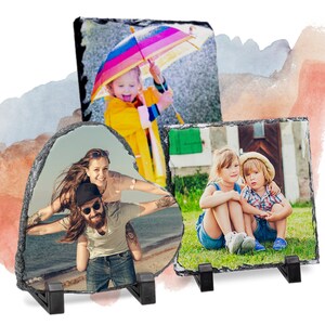 May include: Three slate photo coasters with different images. The first coaster is heart-shaped and features a couple on a beach. The second coaster is square and features a young girl holding a colourful umbrella. The third coaster is square and features two children sitting on the grass.