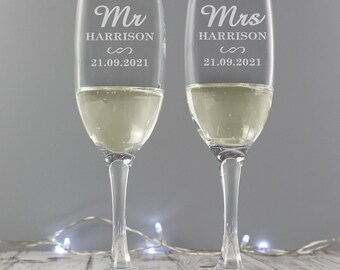 May include: Two champagne flutes with the words "Mr. Harrison" and "Mrs. Harrison" engraved on them. The flutes also have the date "21.09.2021" engraved on them.